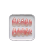 Set of jelly pink (translucent pink) press ons in a clear plastic case on a white background. Silver stars, silver gems, and pearl star, and pearl detailing. 