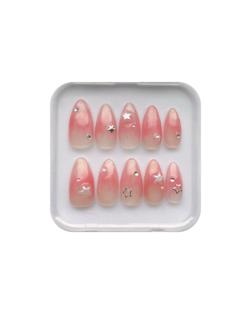 Set of jelly pink (translucent pink) press ons in a clear plastic case on a white background. Silver stars, silver gems, and pearl star, and pearl detailing. 