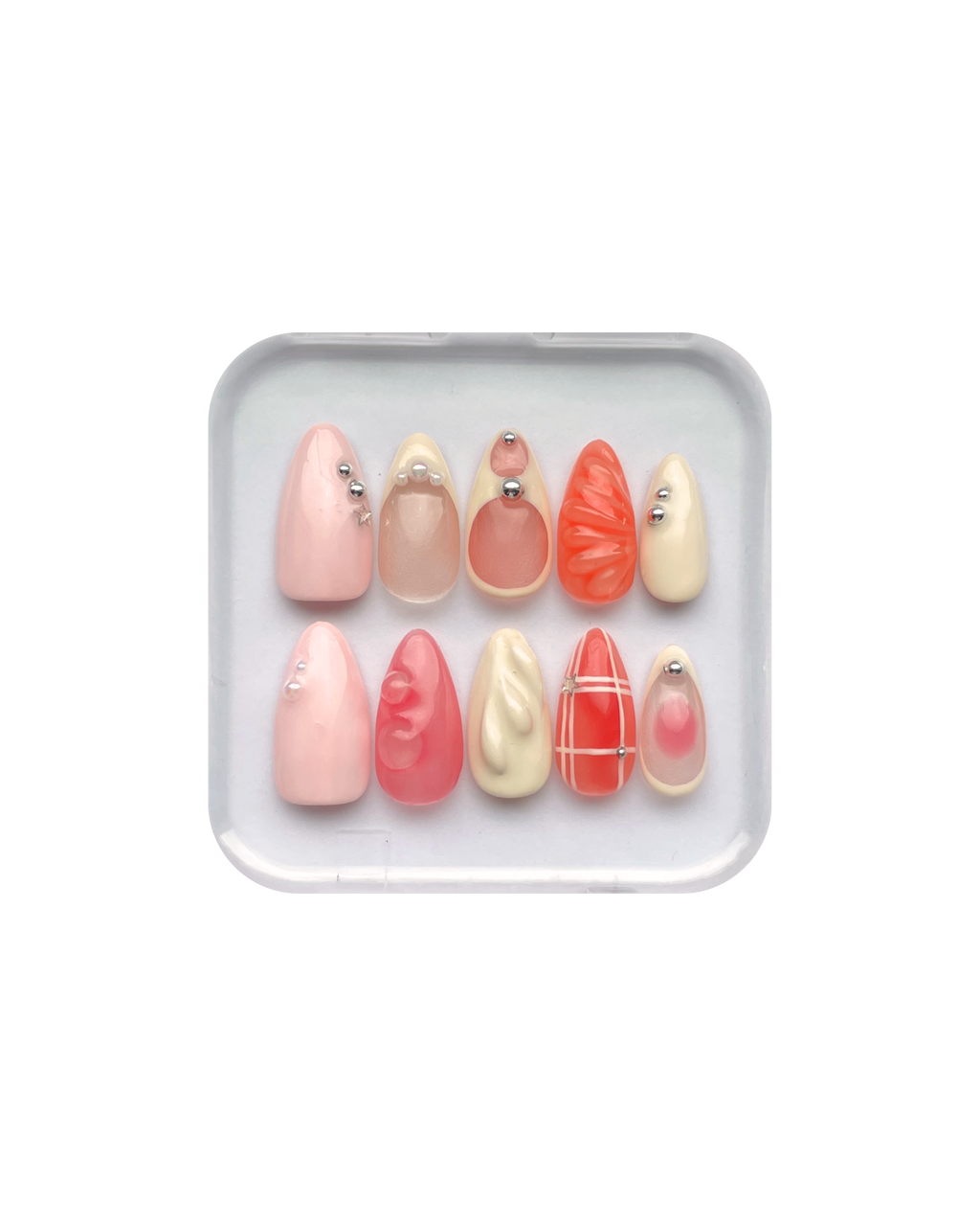 Set of press on nails in orange, pink, pale yellow, and pale pink in a clear plastic case on a white background. Silver and pearl detailing. 