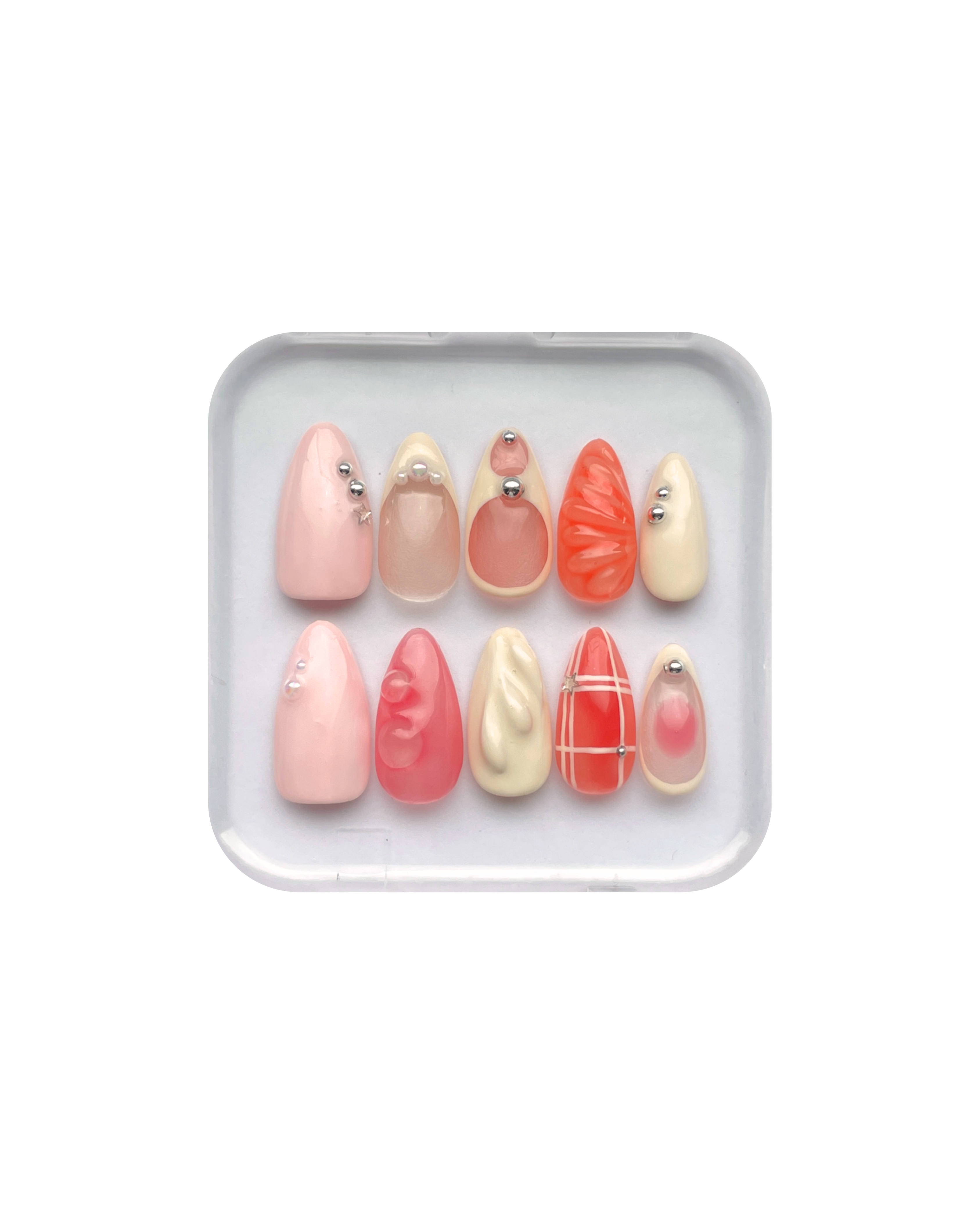Set of press on nails in orange, pink, pale yellow, and pale pink in a clear plastic case on a white background. Silver and pearl detailing. 