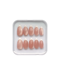 Set of pink press on nails in a clear plastic tray on a white background. Pink cat eye nails with white french tips, all in almond shape. 