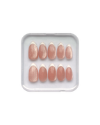 Set of pink press on nails in a clear plastic tray on a white background. Pink cat eye nails with white french tips, all in almond shape. 